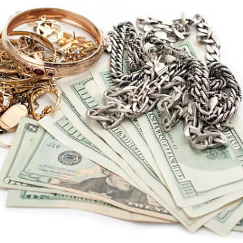 Gold and silver jewelry piled on cash