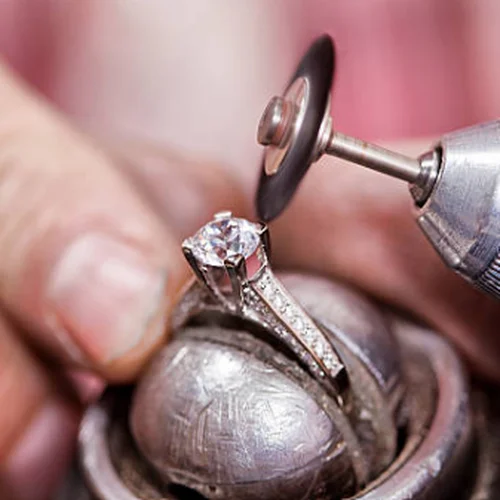 A jeweler polishing a diamond ring at the bench